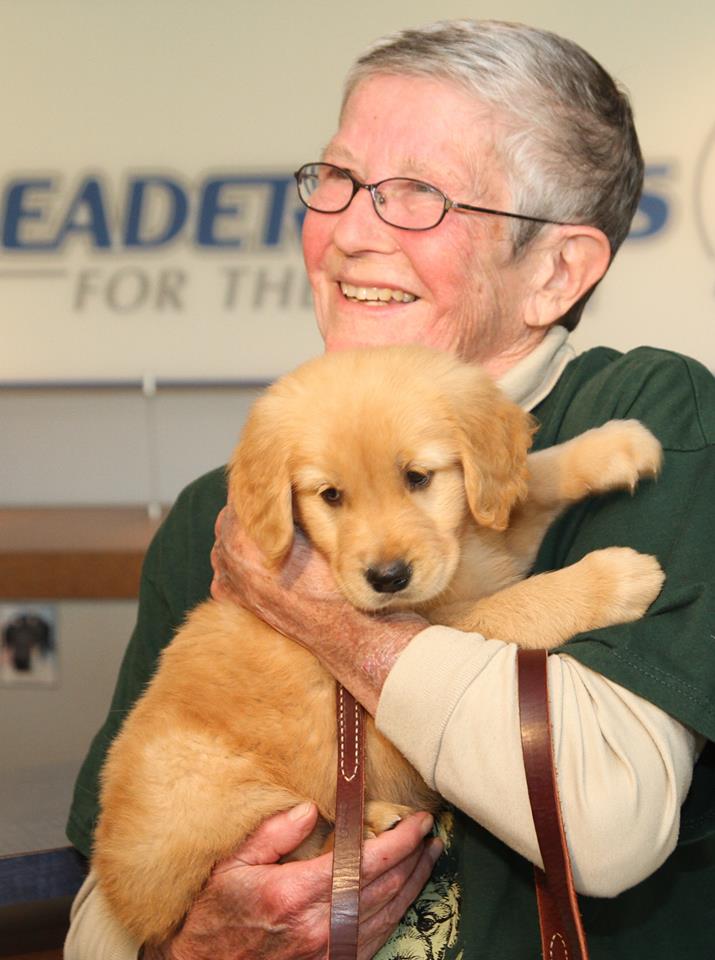 Volunteer puppy raiser Nan Nellenbach picks up "Joy," the 50th puppy she will be raising for Leader Dogs for the Blind. (Credit: Leader Dogs for the Blind/Facebook Photo)