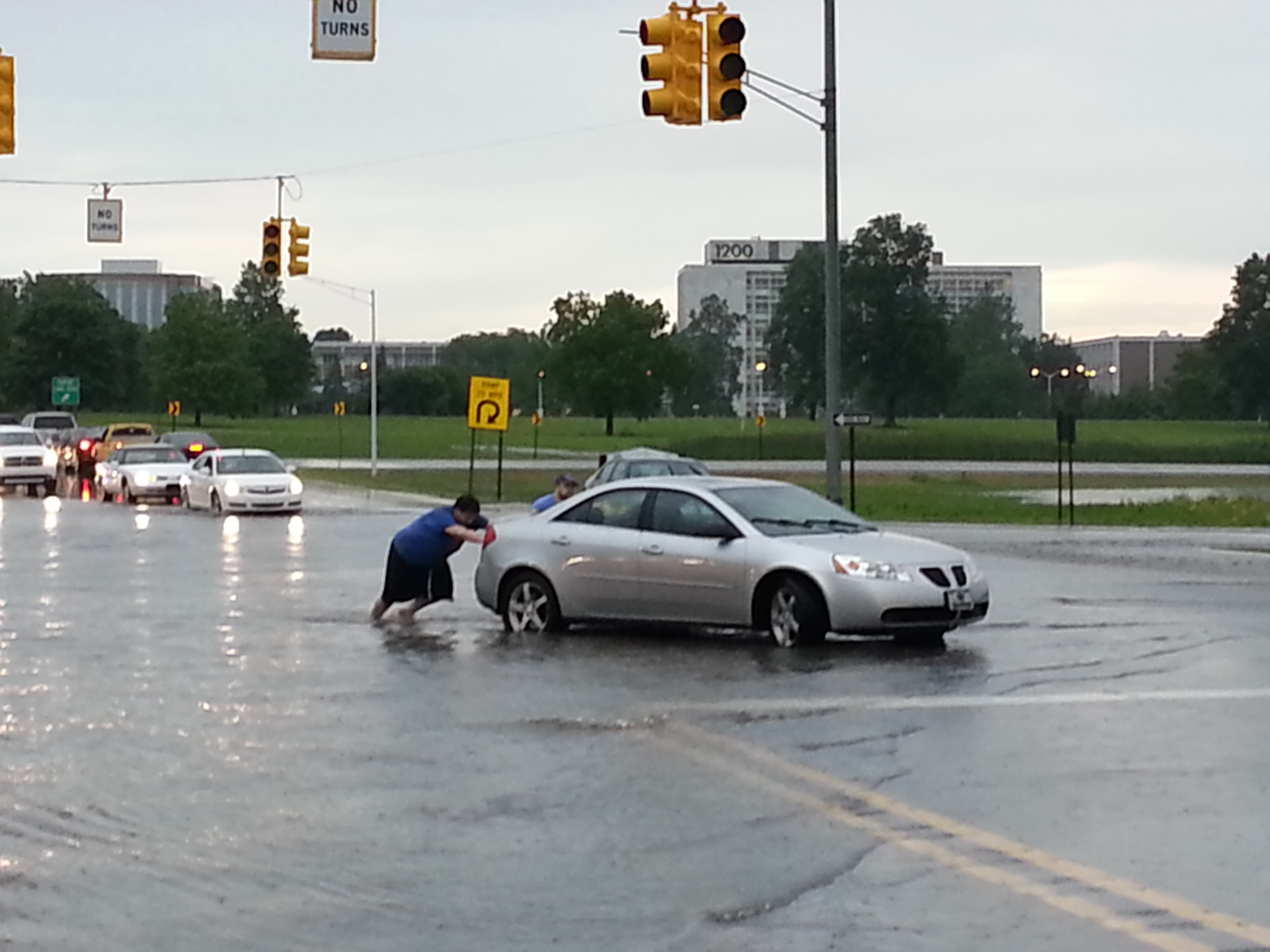 Rhys Vance pushes his car along Telegraph Road in Pontiac. (credit: Jon Hewett/WWJ)