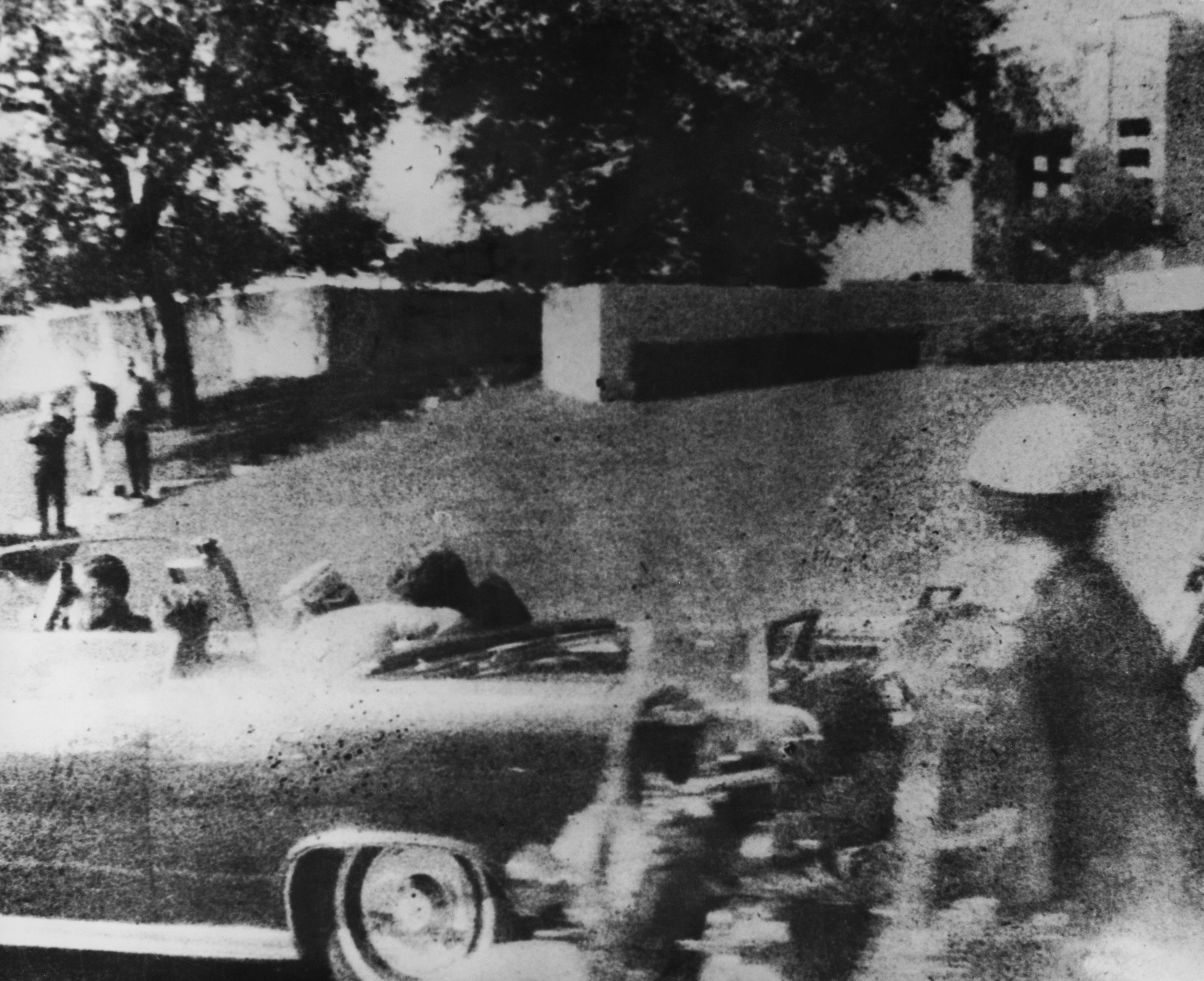American president John F. Kennedy (1917 - 1963) is struck by an assassin's bullet as he travels through Dallas in a motorcade November, 22 1963. In the car next to him is his wife Jacqueline (1929 - 1994) and in the front seat is Texas governor John Connally. (Credit: Three Lions/Hulton Archive/Getty Images) 