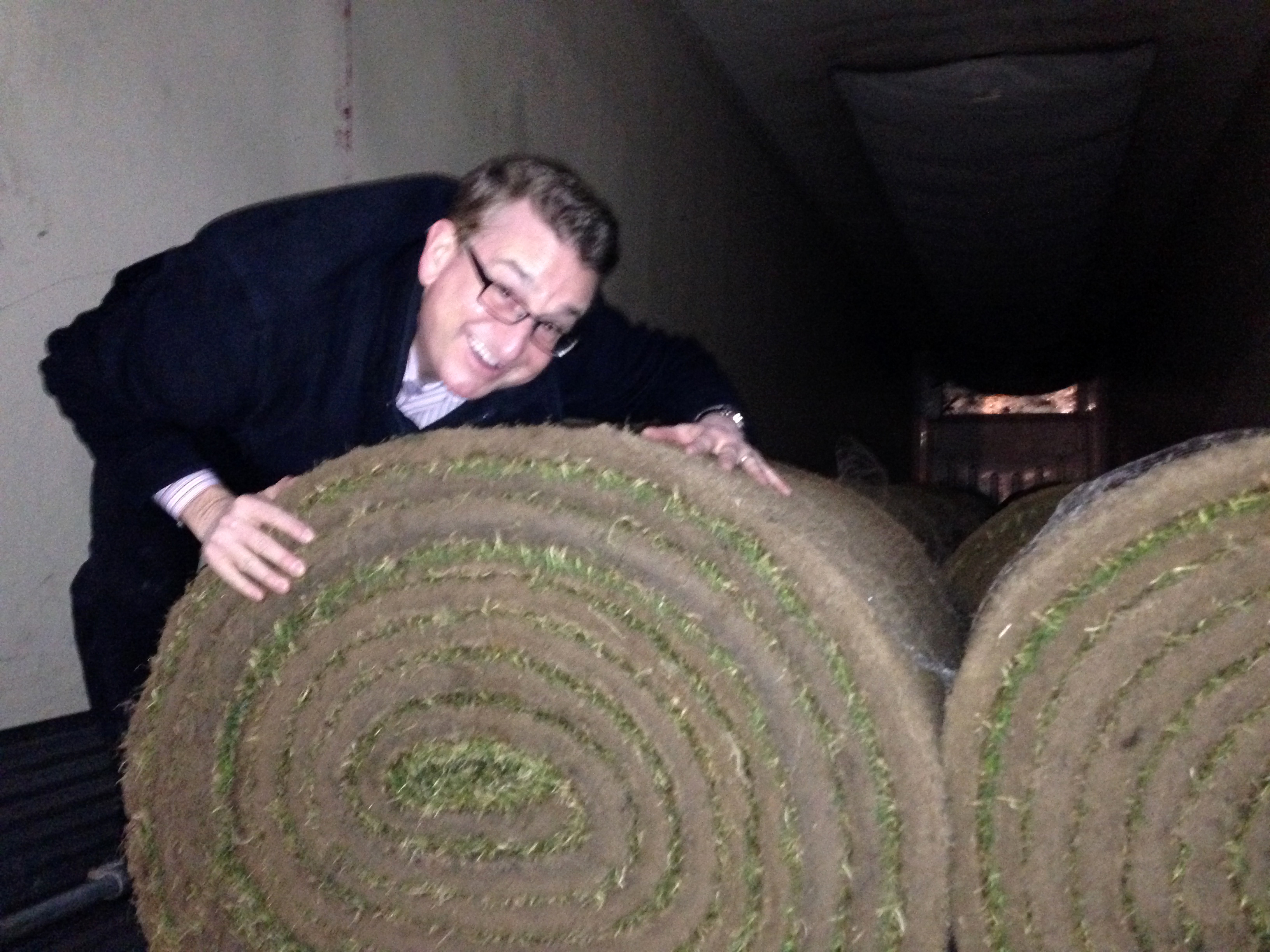 WWJ's Charlie Langton just couldn't keep his hands off of the fresh Kentucky bluegrass, soon to cover the field at Comerica Park. (Credit: WWJ Newsradio 950)