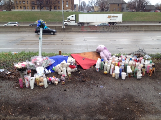 A makeshift memorial was created along the I-75 service drive where three teens were killed when the stolen vehicle they were driving crashed onto the freeway below. (Credit: Mike Campbell/WWJ Newsradio 950)