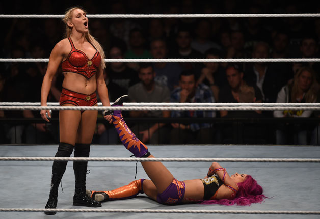 WWE wrestling stars Sasha Bank (R) and Charlotte Flair (L) fight during a WWE (World Wrestling Entertainment) women's fight at the Olympic hall in Munich, southern Germany, on November 3, 2016.